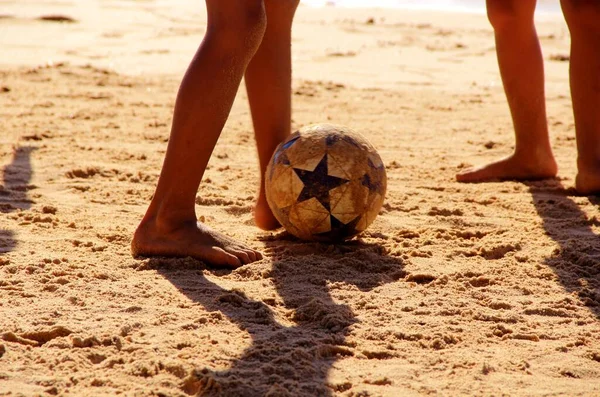 Kumsalda futbol oynayan insanların bacaklarına bakın. 
