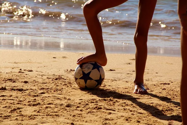 Kumsalda futbol oynayan insanların bacaklarına bakın. 