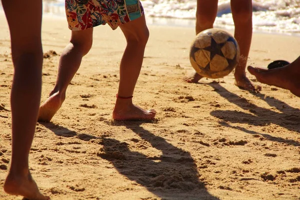 Kumsalda futbol oynayan insanların bacaklarına bakın. 