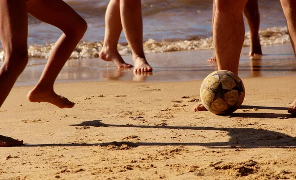 Kumsalda futbol oynayan insanların bacaklarına bakın. 