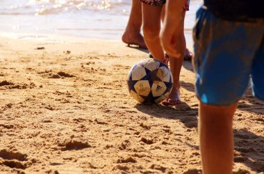 Kumsalda futbol oynayan insanların bacaklarına bakın. 