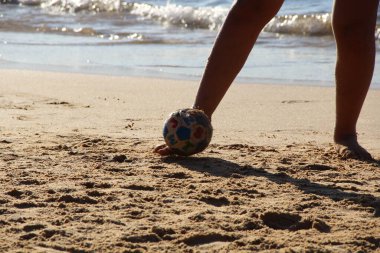 Kumsalda futbol oynayan insanların bacaklarına bakın. 