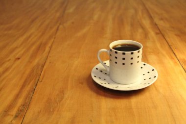 Ahşap arka planda bir fincan dolusu kahve manzarası