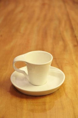 Boş bir kahve fincanını ahşap arka planda bir fincan üzerinde görmek
