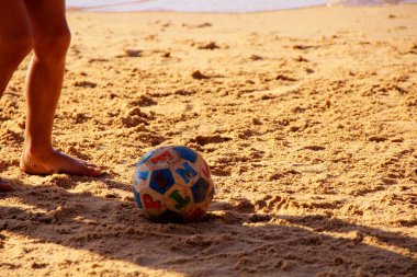 Kumsalda futbol oynayan insanların bacaklarına bakın. 