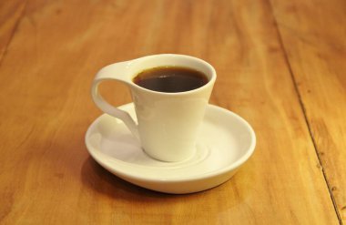 Ahşap arka planda bir fincan dolusu kahve manzarası