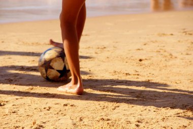 Kumsalda futbol oynayan insanların bacaklarına bakın. 