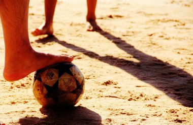 Kumsalda futbol oynayan insanların bacaklarına bakın. 