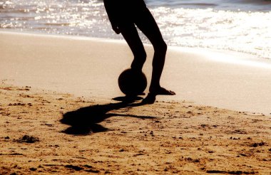 Kumsalda futbol oynayan insanların bacaklarına bakın. 