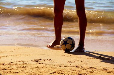 Kumsalda futbol oynayan insanların bacaklarına bakın. 