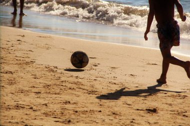Kumsalda futbol oynayan insanların bacaklarına bakın. 