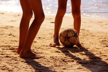 Kumsalda futbol oynayan insanların bacaklarına bakın. 