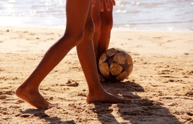 Kumsalda futbol oynayan insanların bacaklarına bakın. 