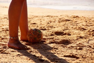 Kumsalda futbol oynayan insanların bacaklarına bakın. 