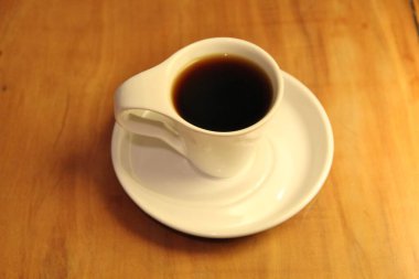 Ahşap arka planda bir fincan dolusu kahve manzarası