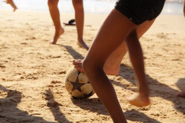 Kumsalda futbol oynayan insanların bacaklarına bakın. 