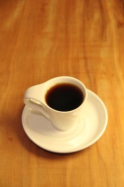 Ahşap arka planda bir fincan dolusu kahve manzarası