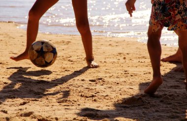 Kumsalda futbol oynayan insanların bacaklarına bakın. 