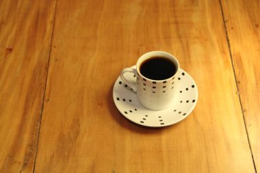 Ahşap arka planda bir fincan dolusu kahve manzarası