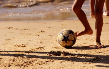 Kumsalda futbol oynayan insanların bacaklarına bakın. 