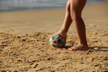 Kumsalda futbol oynayan insanların bacaklarına bakın. 