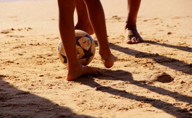 Kumsalda futbol oynayan insanların bacaklarına bakın. 