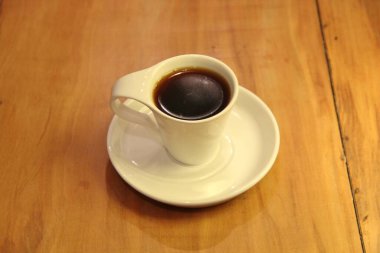 Ahşap arka planda bir fincan dolusu kahve manzarası