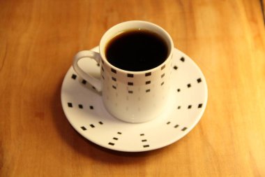 Ahşap arka planda bir fincan dolusu kahve manzarası