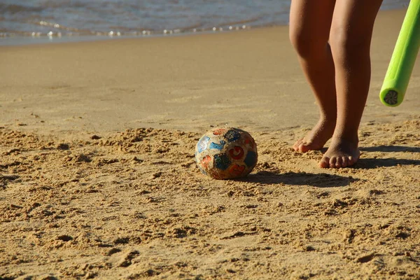 Kumsalda futbol oynayan insanların bacaklarına bakın. 