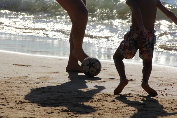 Kumsalda futbol oynayan insanların bacaklarına bakın. 