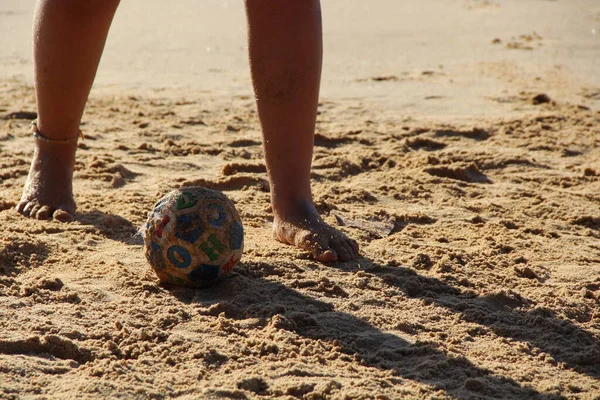 Kumsalda futbol oynayan insanların bacaklarına bakın. 