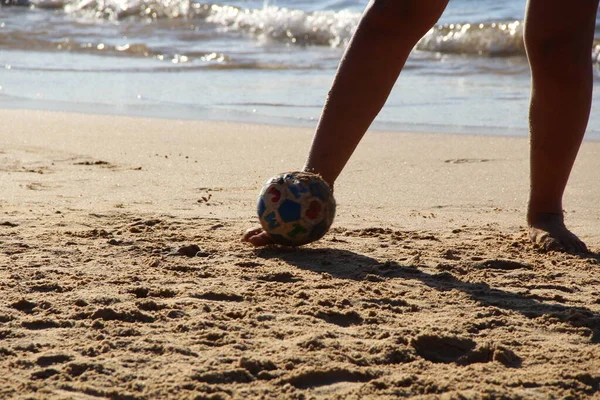 Kumsalda futbol oynayan insanların bacaklarına bakın. 