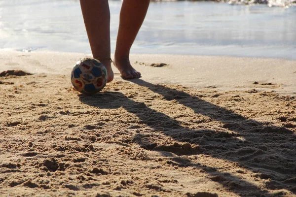 Kumsalda futbol oynayan insanların bacaklarına bakın. 