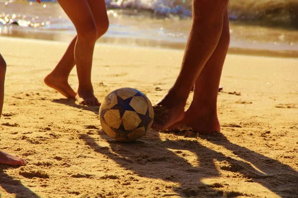 Kumsalda futbol oynayan insanların bacaklarına bakın. 