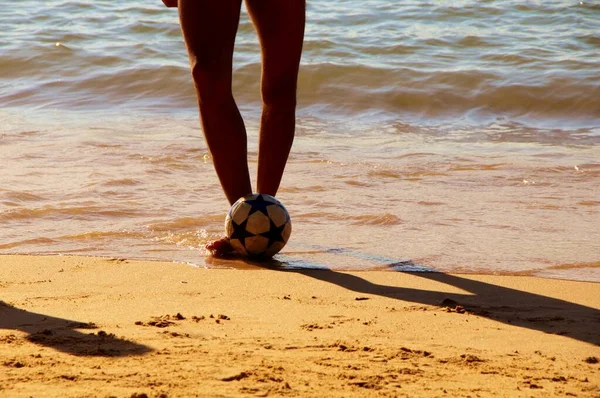 Kumsalda futbol oynayan insanların bacaklarına bakın. 