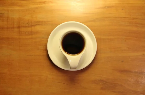 Uitzicht Een Volle Koffiekop Een Schotel Houten Achtergrond — Stockfoto
