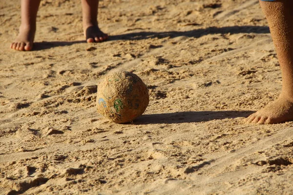 Kumsalda futbol oynayan insanların bacaklarına bakın. 
