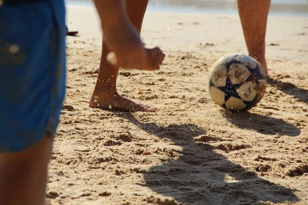 Kumsalda futbol oynayan insanların bacaklarına bakın. 
