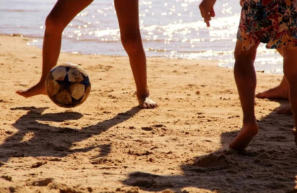 Kumsalda futbol oynayan insanların bacaklarına bakın. 
