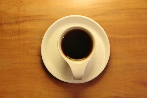 Άποψη Ενός Πλήρους Φλιτζανιού Καφέ Ένα Πιατάκι Ξύλινο Φόντο — Φωτογραφία Αρχείου