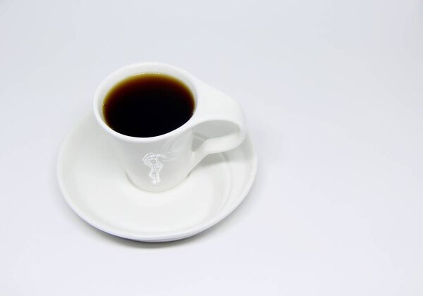 View of a full coffee cup on a saucer in white background 