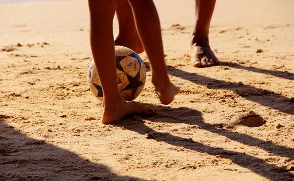 Kumsalda futbol oynayan insanların bacaklarına bakın. 