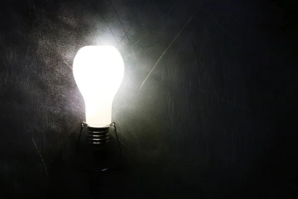 Светящаяся лампочка на черном фоне — стоковое фото