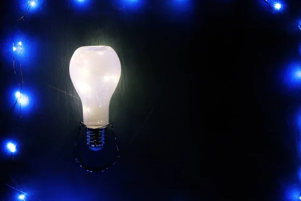 Glühende Glühbirne auf schwarzem Hintergrund — Stockfoto