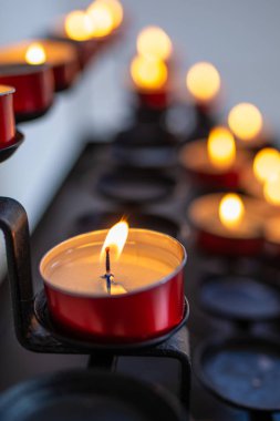 Koyu arkaplanda mumlar yakılıyor.