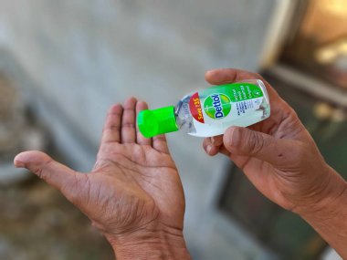 Jaipur, India-Circa 2020: Ellerini dezenfektanla temizleyen birinin resmi. Bu korona virüsü salgını sırasında hijyen önemlidir.  