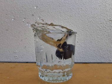 Su damlacıklarının su bardağından fışkırması.