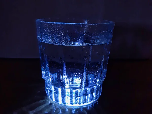 Картина Ілюмінованого Склянки Води Краплями Води Над Нею Знята Темному — стокове фото