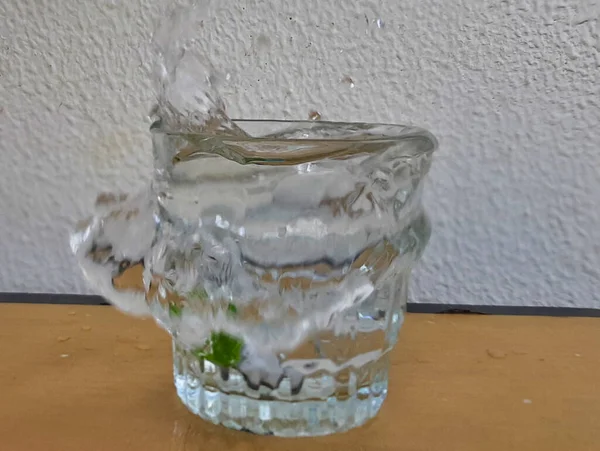Bild Von Wasserspritzern Die Durch Ein Glas Wasser Austreten — Stockfoto