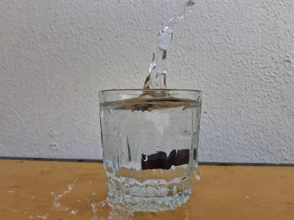 Bild Von Wasserspritzern Die Durch Ein Glas Wasser Austreten — Stockfoto